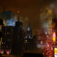 A man wearing a red helmet and armor stands on a dark rooftop overlooking Gotham City at night.